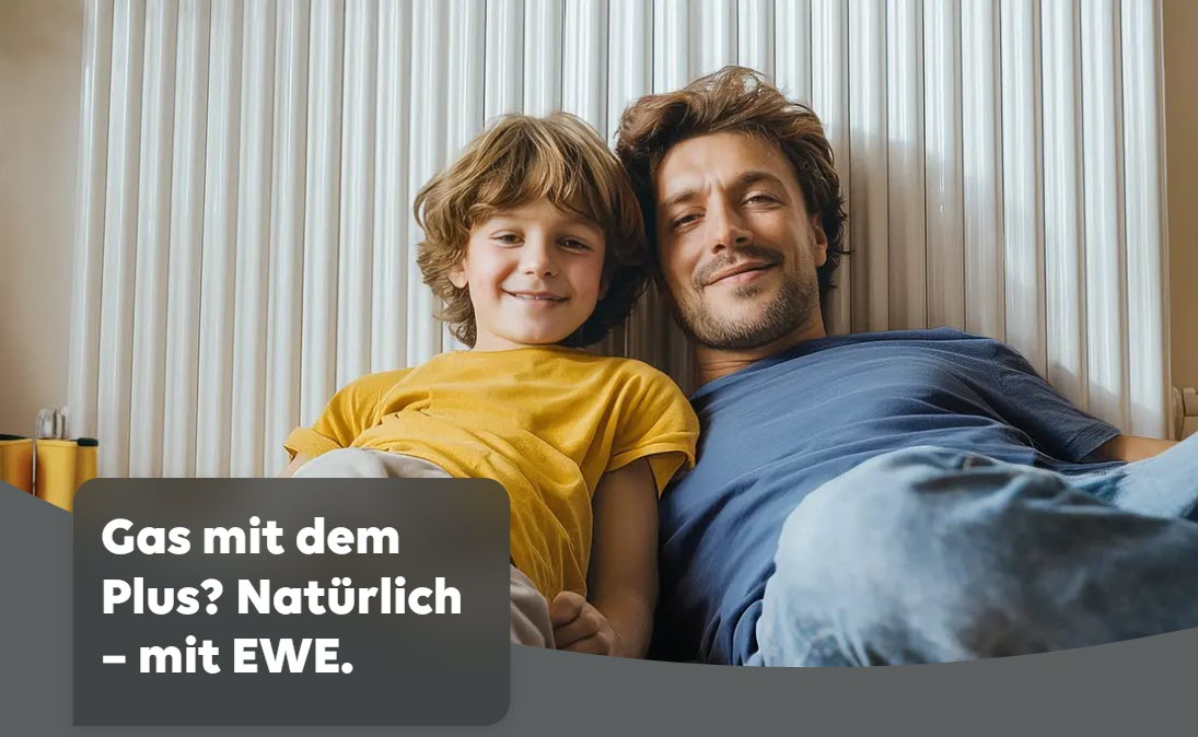 Dekoratives Bild. Ein Mann und ein junges Kind sitzen vor einem Heizkörper und lächeln in die Kamera